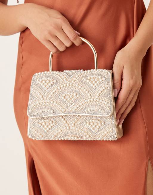Bolso color crema con asa superior y diseño adornado con perlas de True Decadence
