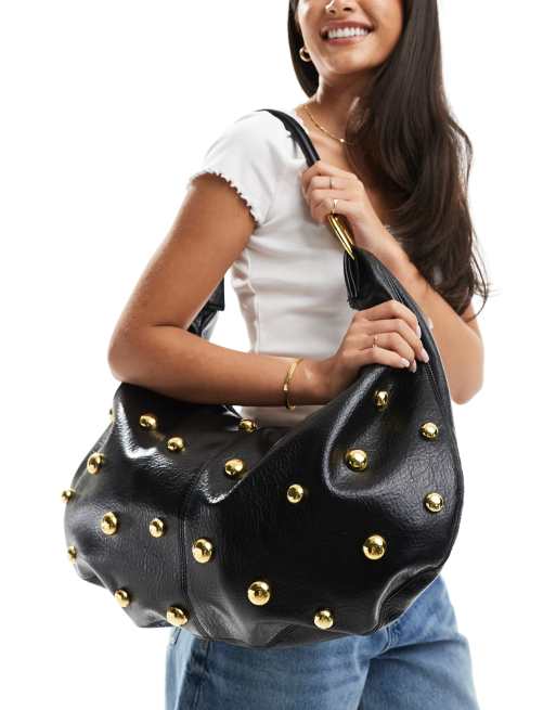 Bolso tote negro curvado con detalle de tachuelas y anillas metálicas de ASOS DESIGN