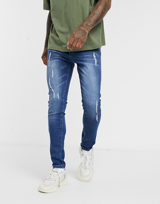 boohooMAN distressed skinny jeans in mid wash blue