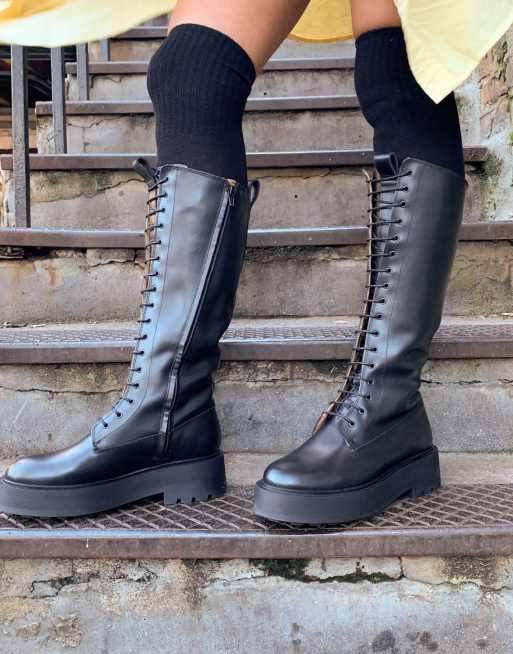 Botas altas negras planas de suela gruesa con cordones de cuero de