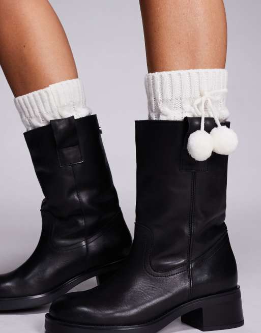 Calentadores para las piernas color crema con detalle de pompones exclusivos de Kaiia