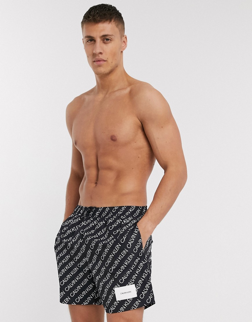 Calvin Klein all over logo crew recycled swim shorts in black co-ord