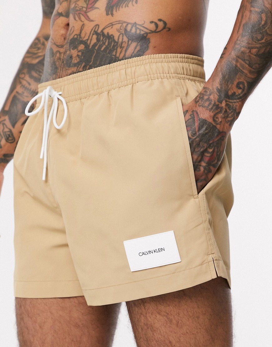 Calvin Klein – Beige badshorts av återvunnet material med påsydd logga