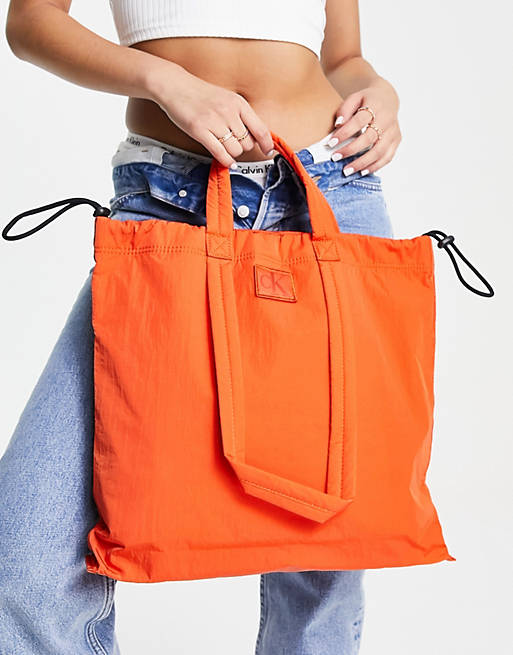 Calvin Klein Jeans city nylon square tote bag in coral orange | ASOS