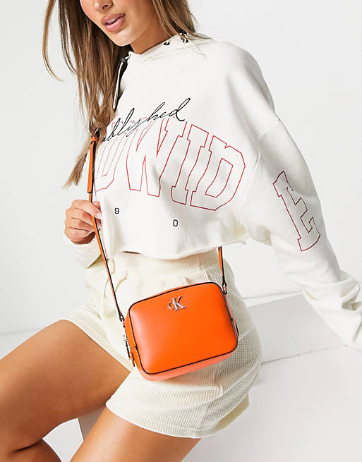 Calvin Klein Jeans CK logo camera bag in orange | ASOS