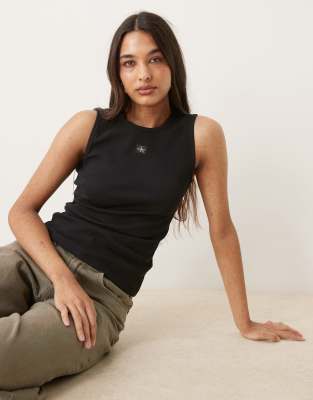 Calvin Klein Jeans - Geripptes Tanktop in Schwarz mit Logo-Etikett aus Webstoff