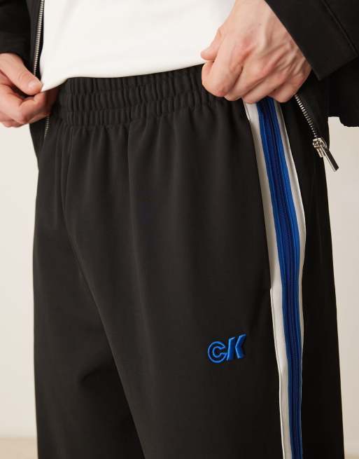 Calvin Klein Jeans stripe track pants in black and blue ASOS