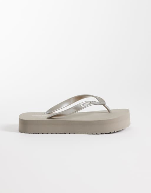 Calvin Klein Jeans – Zehensteg-Sandalen in Metallic-Cremeweiß mit flacher Plateausohle, 3 von 4