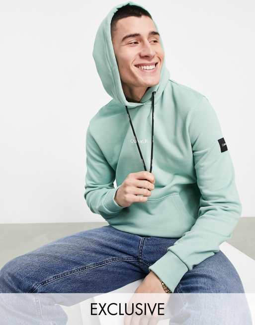 Calvin Klein – Kapuzenpullover in Blaugrün mit mittigem Logo, exklusiv bei ASOS