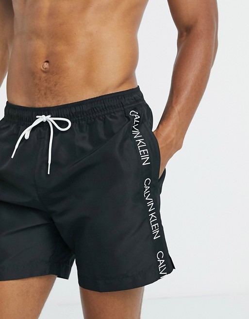 Calvin Klein logo tape swim shorts in black | ASOS