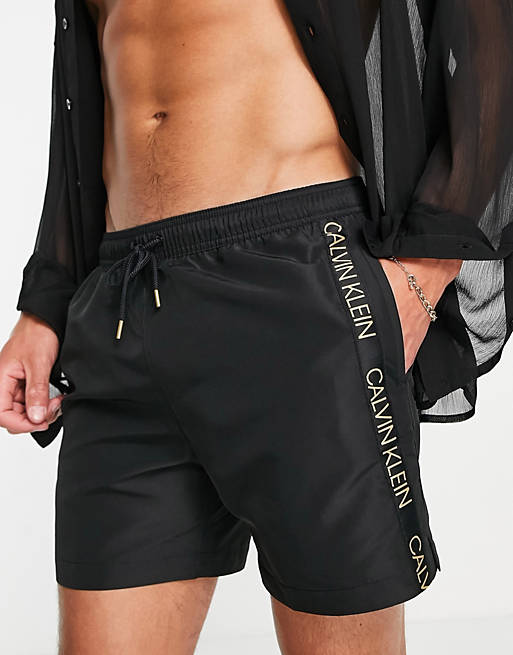 Calvin Klein swimshorts with gold logo side taping in black