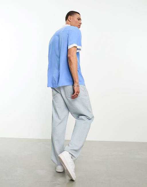 Camisa azul holgada con cuello de solapas estilo bolera y detalle