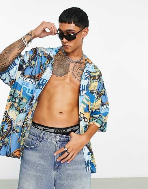 Camisa extragrande con estampado de parches de postales, solapas y sisas caídas de ASOS DESIGN