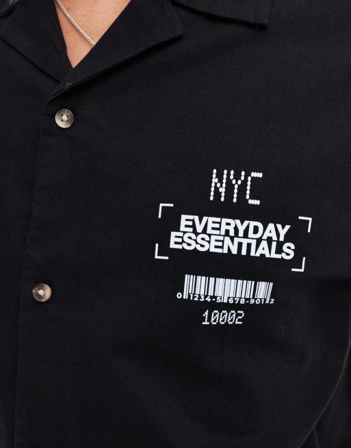 Camisa negra holgada con cuello de solapas y estampado en el pecho