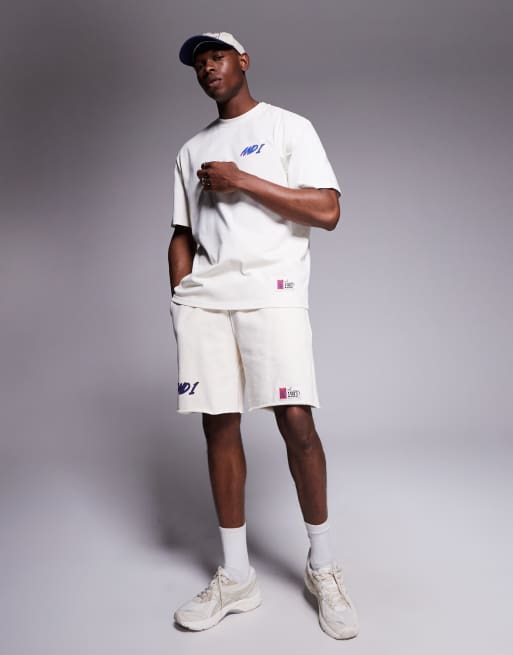 Camiseta blanca extragrande con estampado deportivo en la espalda y logo de AND1, 3 de 4