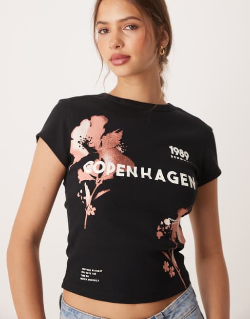 Camiseta negra con diseño encogido y estampado gráfico de flor descolorida y texto 