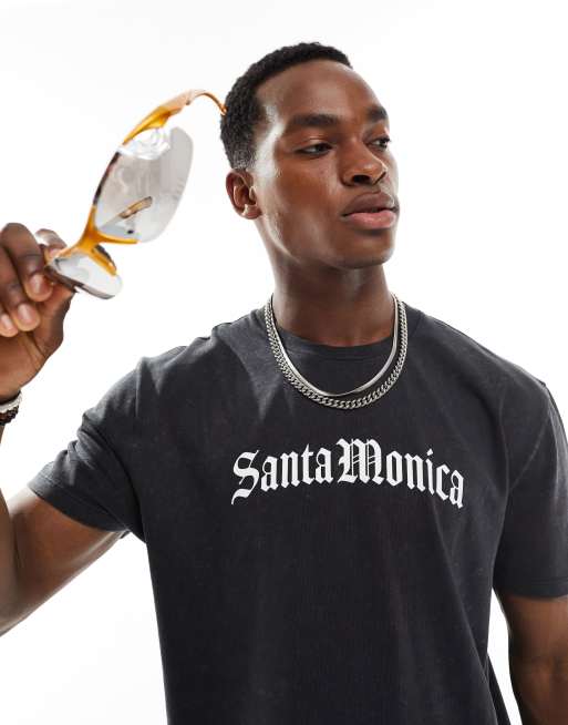 Camiseta negro lavado holgada con estampado de palmeras en la espalda de ASOS DESIGN