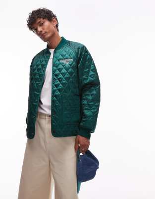 Carhartt WIP – Alumni – Grön, quiltad jacka med broderad logga - view 1