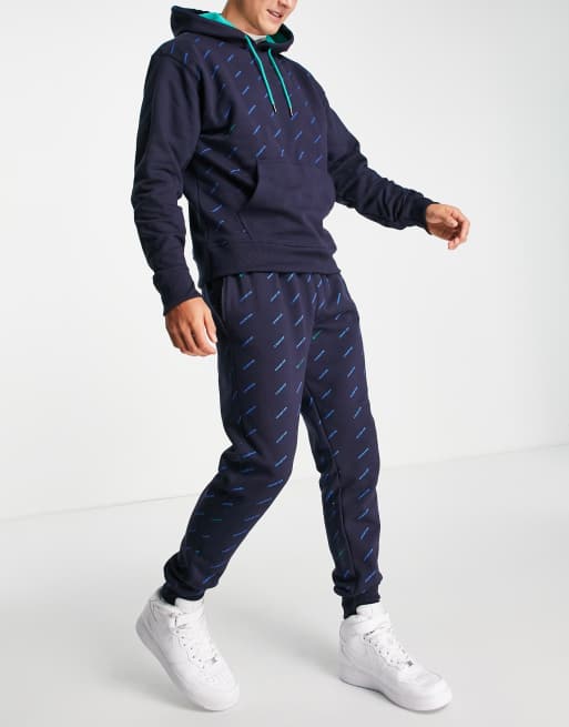 Champion all over logo print sweatpants in navy ASOS