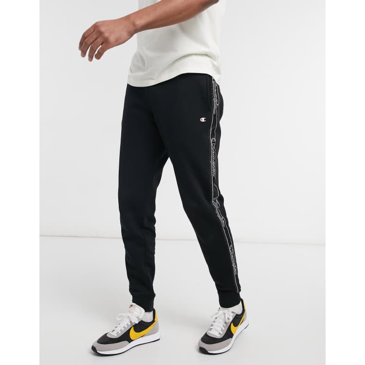 Champion large logo trackies in black with taping ASOS