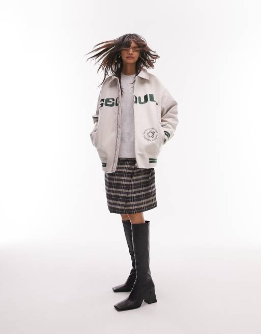 Chaqueta bomber color crema universitaria con solapas y estampado gráfico 