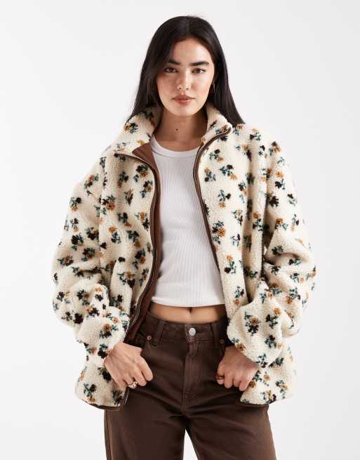 Chaqueta color crema con cremallera, estampado de florecitas y ribetes marrones en contraste de borreguito de Daisy Street