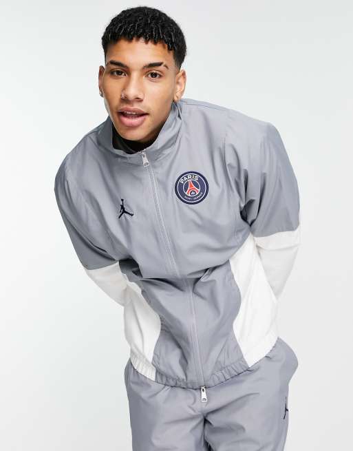 Chaqueta de ch ndal gris y blanca con cremallera y dise o del Paris Saint Germain de Jordan