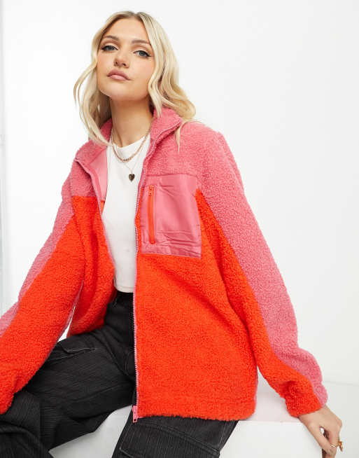 Chaqueta rosa luminoso y rojo de felpa con diseño color block y ribetes en contraste de Pieces