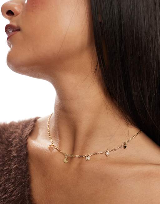 Collar dorado con charms celestiales y letra M chapado en oro de la colección Z de Accessorize