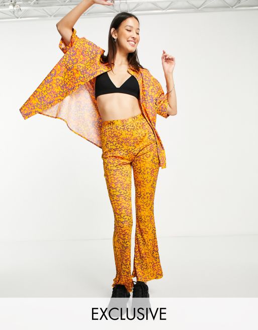 COLLUSION - Pantaloni a zampa plissé con stampa a fiori astratta color pesca in coordinato