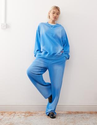 COLLUSION - Sweatshirt in verwaschenem Blau mit rotem Logo-Aufnäher, Kombiteil