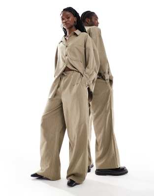Collusion COLLUSION Unisex co-ord balloon trousers in brown pinstripe with print