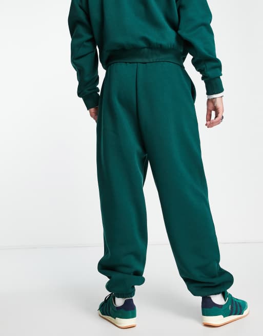 COLLUSION varsity print joggers in dark green