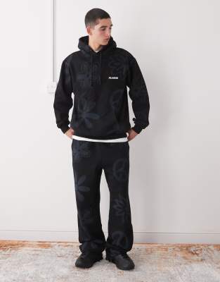 Conjunto negro de joggers y sudadera con capucha y estampado de símbolo ...