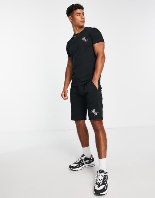 Conjunto negro de pantalones cortos y camiseta con logo de texto de FCUK