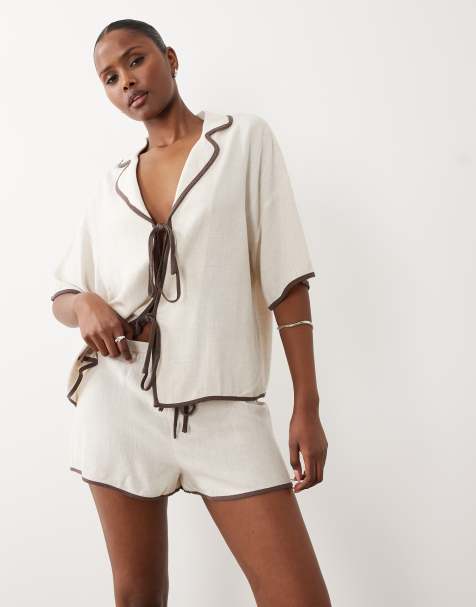 Conjunto playero color crema de pantalones cortos y camisa con solapas, lazada delantera y ribete en contraste de tejido efecto lino exclusivo de The Frolic - view 1