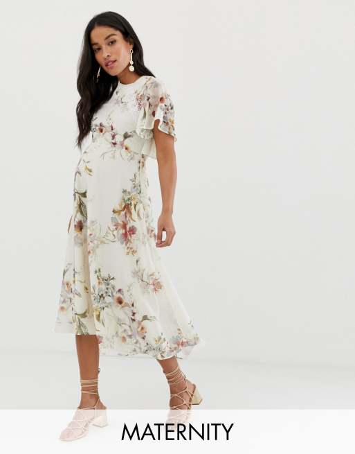 Cremefarvet og blomstret midikjole med åben ryg i ventetøj model fra Hope & Ivy
