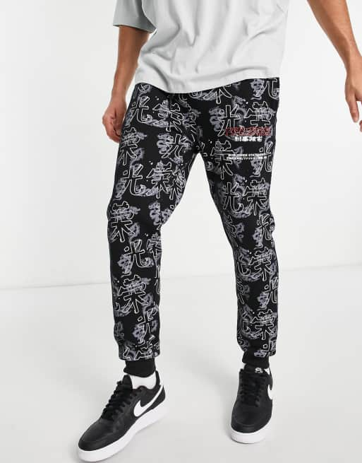 Shinkan Reception Vittig Criminal Damage all-over print sweatpants in black - part of a set | ASOS