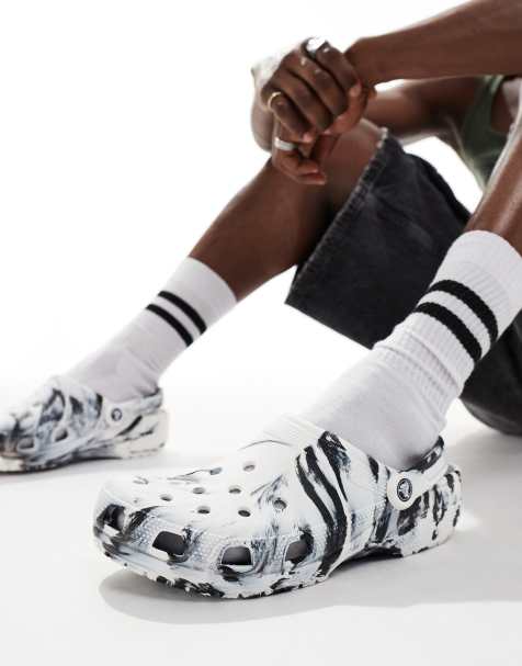 Crocs – Svarta och vita, klassiska tofflor i unisex-modell med marmorerat mönster - view 1