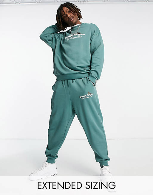 Crooked Tongues relaxed sweatpants with logo and dogs graphic print in dark green