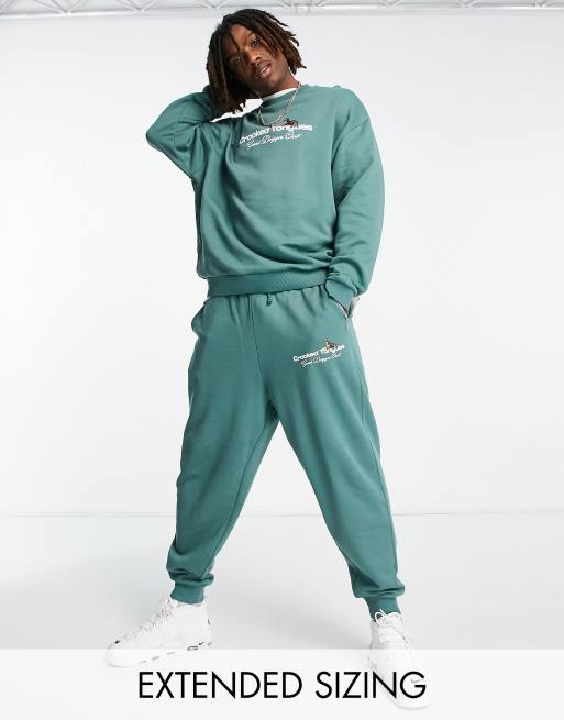 Crooked Tongues relaxed trackies with logo and dogs graphic print in dark green