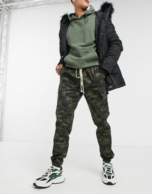 фото Джоггеры в стиле милитари с темным камуфляжным принтом и карманами-карго sixth june-зеленый