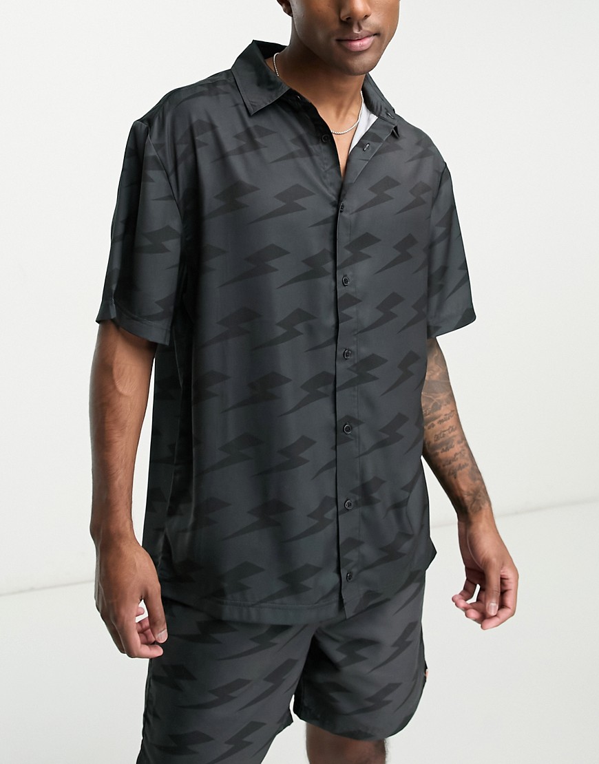 ellesse Capri co-ord shirt with lightning bolt print in black