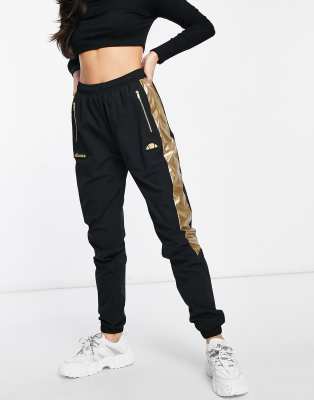 ellesse track pants in black and gold 