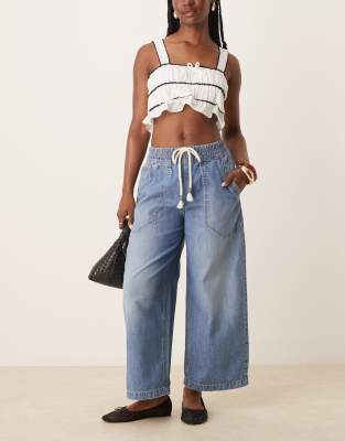 Free People - Jeans in mittelblauer Waschung mit Schnürdetail und abgerundetem Beinschnitt