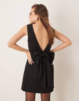 mini dress with low v back and oversized bow detail at back in black