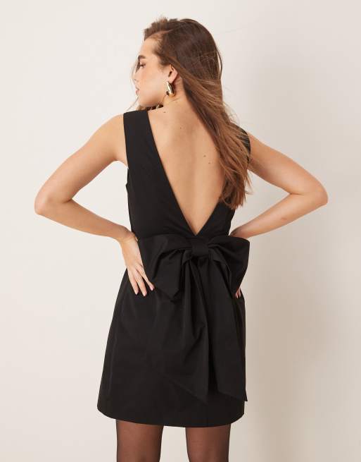 Gina Tricot – Minikleid in Schwarz mit tiefem V-Rückenausschnitt und überdimensionaler Rückenschleife