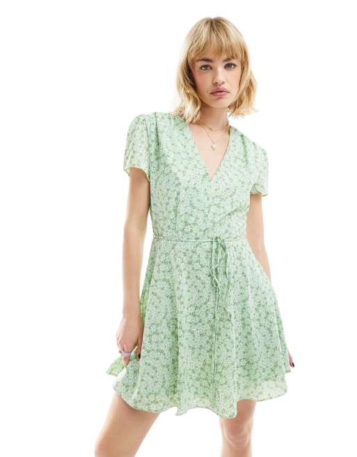 Glamorous – Kurzärmliges Mini-Freizeitkleid in Grün mit Gänseblümchenmuster, V-Ausschnitt und Taillenbindung