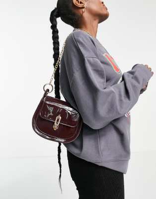 Glamorous patent saddle bag with gold hardware in oxblood