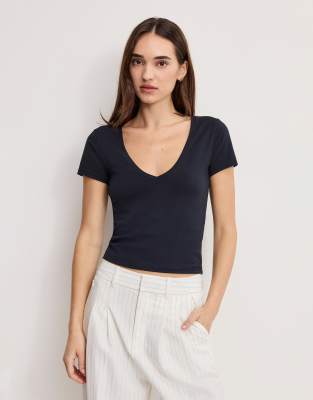 Good American - Knapp geschnittenes T-Shirt in Schwarz mit V-Ausschnitt